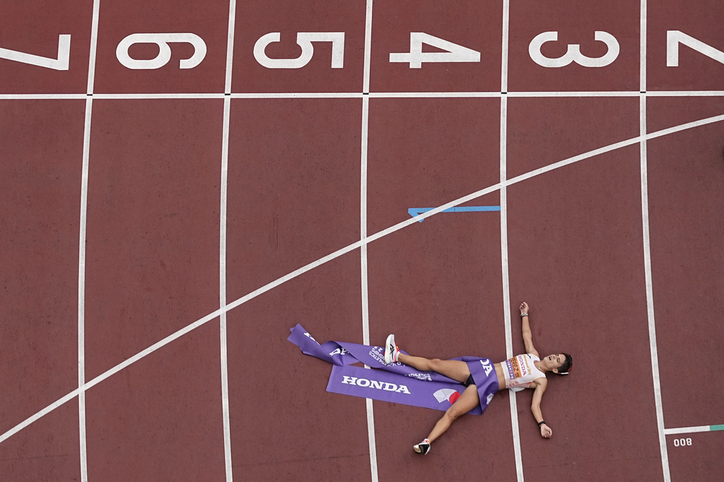Spain's Maria Perez lays on the track after winning the women's 20 kilometers race walk at the World Athletics Championships in Tokyo, Saturday, Sept. 20, 2025. (AP Photo/Bernat Armangue)