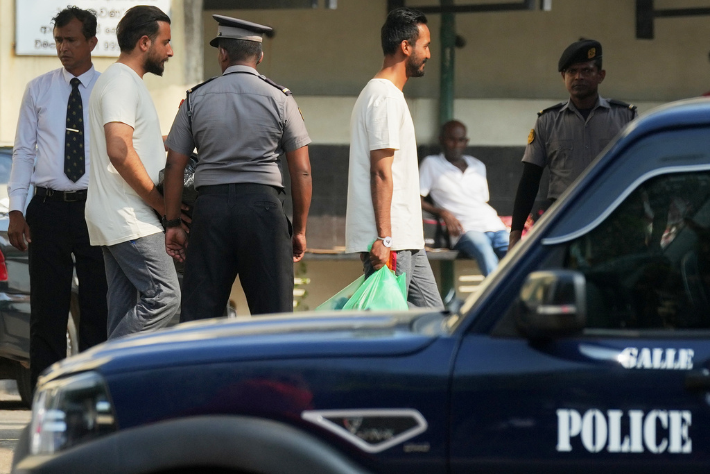 Iranian sailors, wearing t-shirts, who were rescued from IRIS Dena warship by Sri Lanka's navy, are escorted to a Judicial Medical Officer from the National Hospital, in Galle, Sri Lanka, Thursday, March 5, 2026. (AP Photo/Eranga Jayawardena)