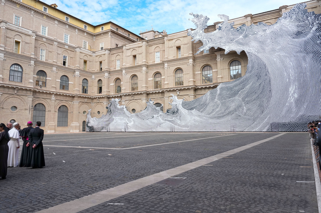 Pope Leo XIV, left, looks at the installation "Diluvium" by French artist Jean Rene, known as JR, as he arrives at the Vatican Library, Monday, Sept. 14, 2026, during a press preview of the exhibit "AQVA, Catastrophe and Wonder," which will be open to the public from Sept. 25 through May 14, 2027. (AP Photo/Andrew Medichini)
