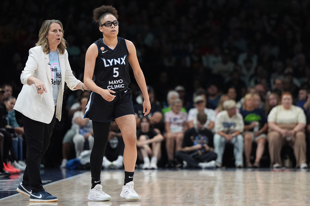 Minnesota Lynx head coach Cheryl Reeve, left, and guard Olivia Miles (5) stand on the court during the first half of a WNBA basketball game against the Indiana Fever, Sunday, Aug. 2, 2026, in Minneapolis. (AP Photo/Abbie Parr)