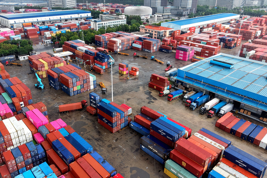 Containers are loaded and unloaded in trucks at terminal in Qingdao in eastern China's Shandong province on Aug. 28, 2026. (Chinatopix via AP)