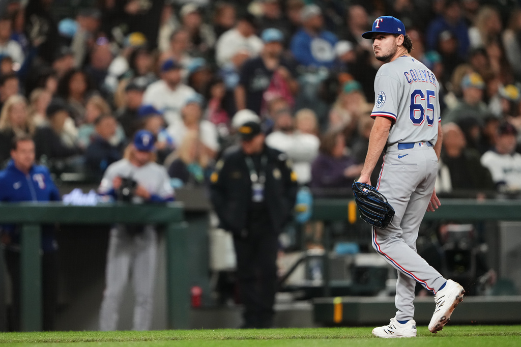 Texas Rangers relief pitcher Gavin Collyer walks back to the dugout after the fifth inning of a baseball game against the Seattle Mariners, Friday, April 17, 2026, in Seattle. (AP Photo/Lindsey Wasson)