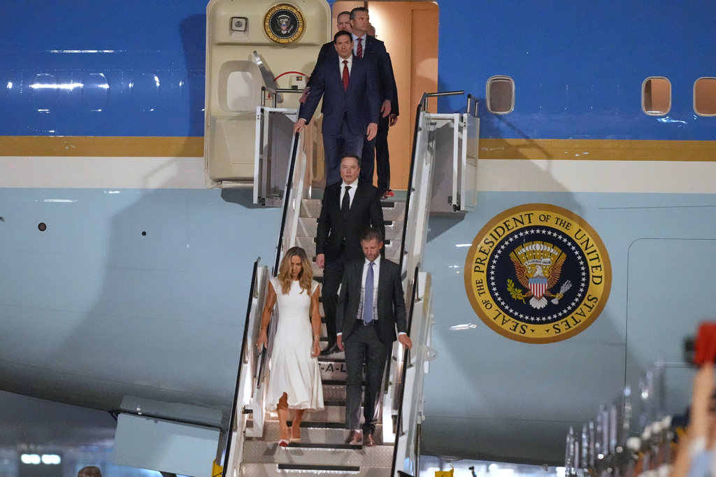 Eric and Lara Trump, followed by Elon Musk, Secretary of State Marco Rubio, Defense Secretary Pete Hegseth, U.S. Trade Representative Jamieson Greer and NVIDIA CEO Jensen Huang walk from Air Force One after arriving with President Donald Trump, Wednesday, May 13, 2026, at Beijing Capital International Airport in Beijing. (AP Photo/Mark Schiefelbein)