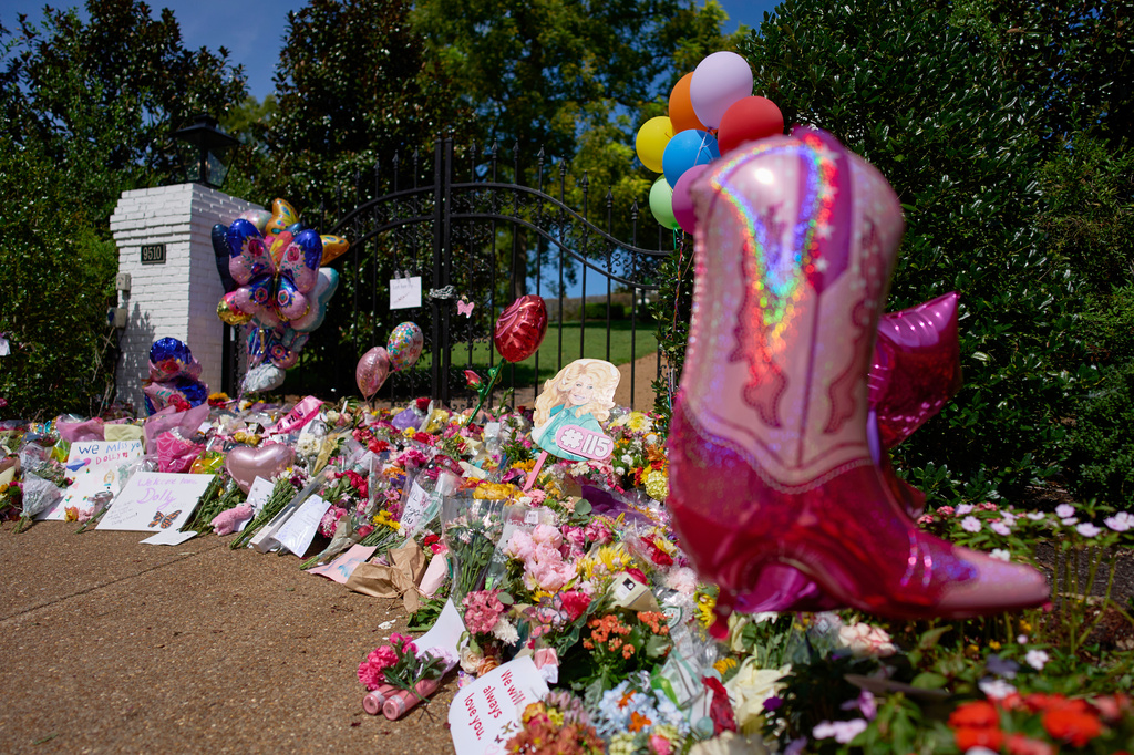 Flowers, cards and balloons are seen at a memorial outside the home of the late Dolly Parton, Thursday, Aug. 27, 2026, in Brentwood, Tenn. (AP Photo/George Walker IV)