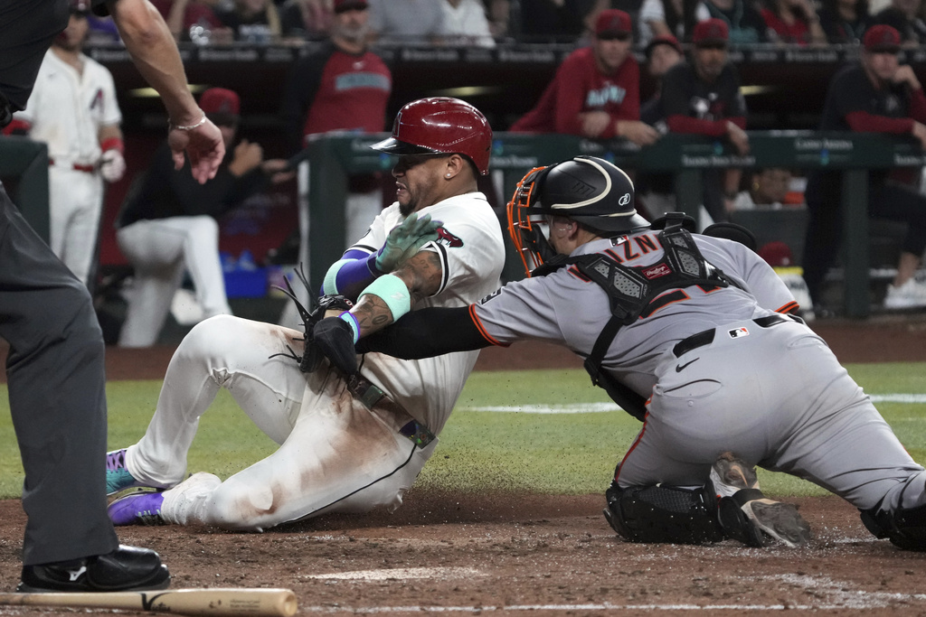 San Francisco Giants catcher Andrew Knizner, right, tags out Arizona Diamondbacks' Ketel Marte trying to score on a ball hit by Diamondbacks' Blaze Alexander in the seventh inning of a baseball game, Tuesday, Sept. 16, 2025, in Phoenix. (AP Photo/Rick Scuteri)