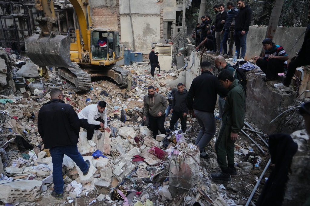Civilians and rescue workers search through rubble at the site of a building where efforts continue to recover the body of missing woman Zahraa Aboud, 26, after it was destroyed in an Israeli airstrike on Wednesday, in central Beirut, Sunday, April 12, 2026. (AP Photo/Hassan Ammar)