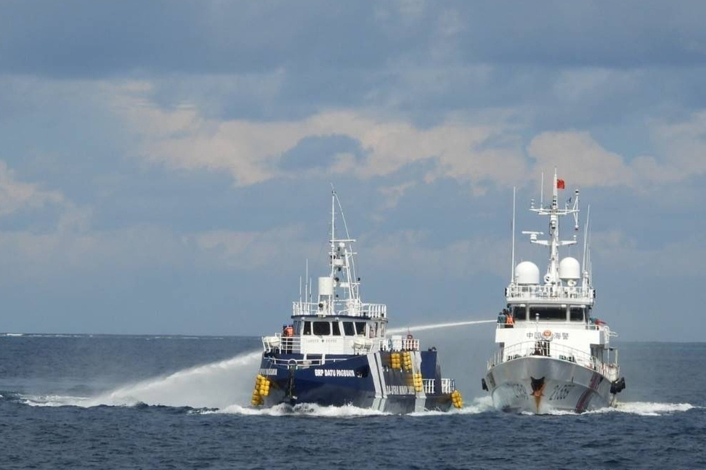 In this photo provided by the Philippine Coast Guard, a Chinese Coast Guard vessel, right, fires it's water cannon at the Philippine's BRP Datu Pagbuaya near Philippine occupied Thitu island locally called Pag-asa island at the South China Sea on Sunday Oct. 12, 2025. (Philippine Coast Guard via AP)
