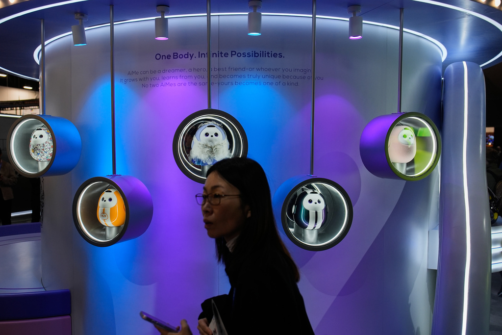 A person walks past a display of the AiMe AI robots at the TCL booth during the CES tech show Wednesday, Jan. 7, 2026, in Las Vegas. (AP Photo/John Locher)