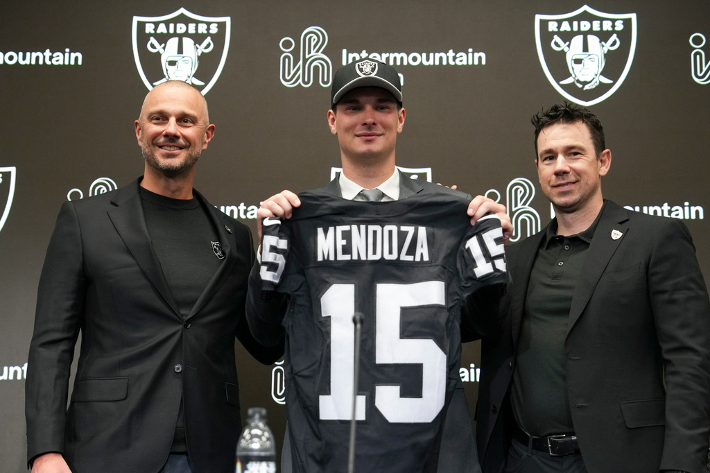 From left to right, Las Vegas Raiders general manager John Spytek, first-round draft pick Fernando Mendoza and head coach Klint Kubiak pose for a photo during an NFL football news conference Friday, April 24, 2026, in Henderson, Nev. (AP Photo/Candice Ward)