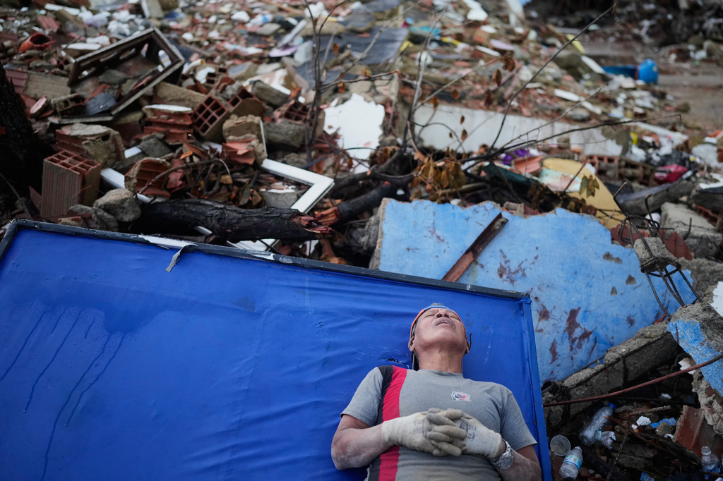 Resident Kerli Faria takes a break amid the rubble while searching for her nephews at a building that collapsed during the earthquakes that struck La Guaira, Venezuela, Tuesday, June 30, 2026. (AP Photo/Ariana Cubillos)
