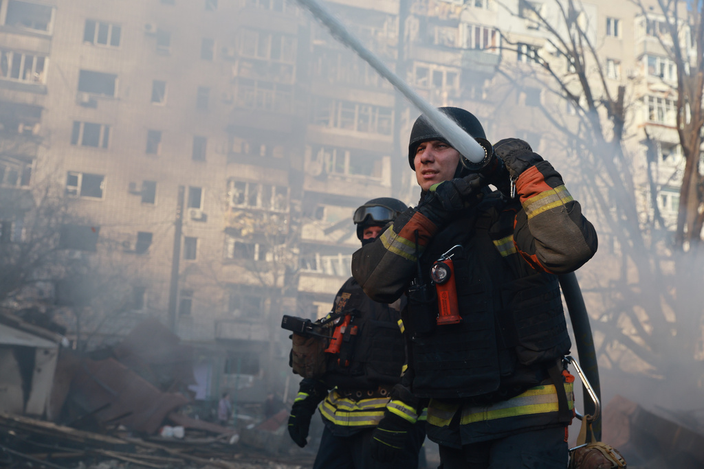 Firefighters put out the fire at a residential neighborhood damaged by Russian aerial guided bomb in Zaporizhzhia, Ukraine, Saturday, March 14, 2026. (AP Photo/Kateryna Klochko)