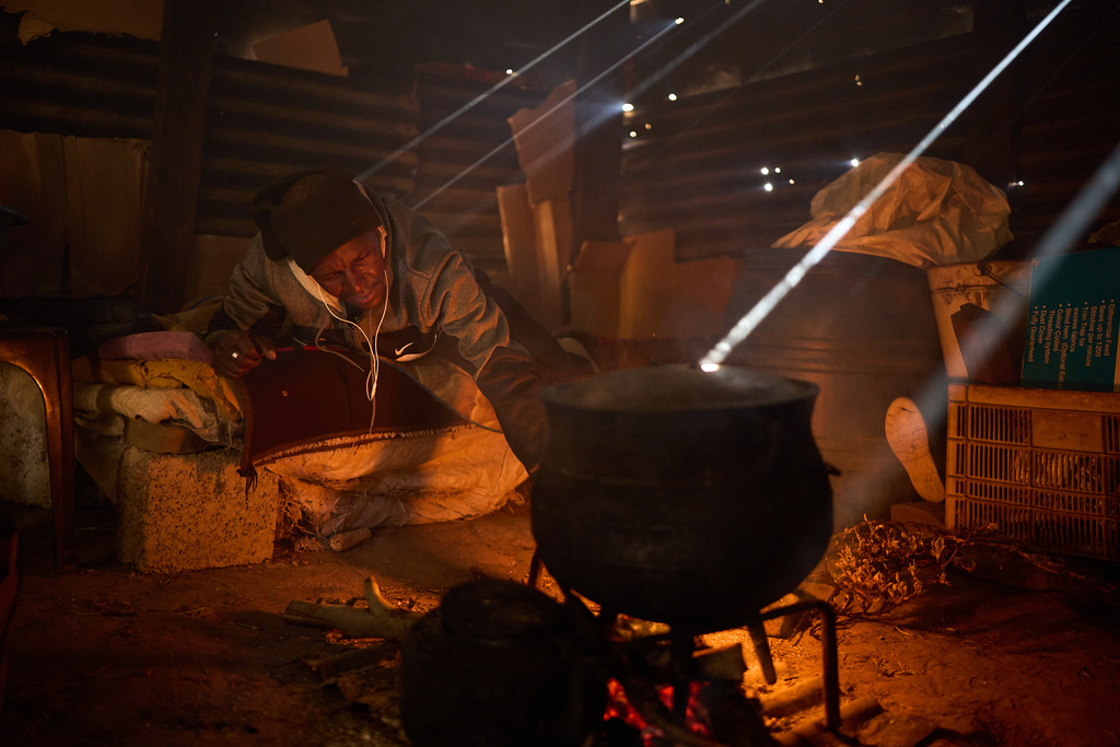 FILE - Matli Monyamane cooks a meal in Ha Lejone, Lesotho, July 22, 2025. (AP Photo/Bram Janssen, File)