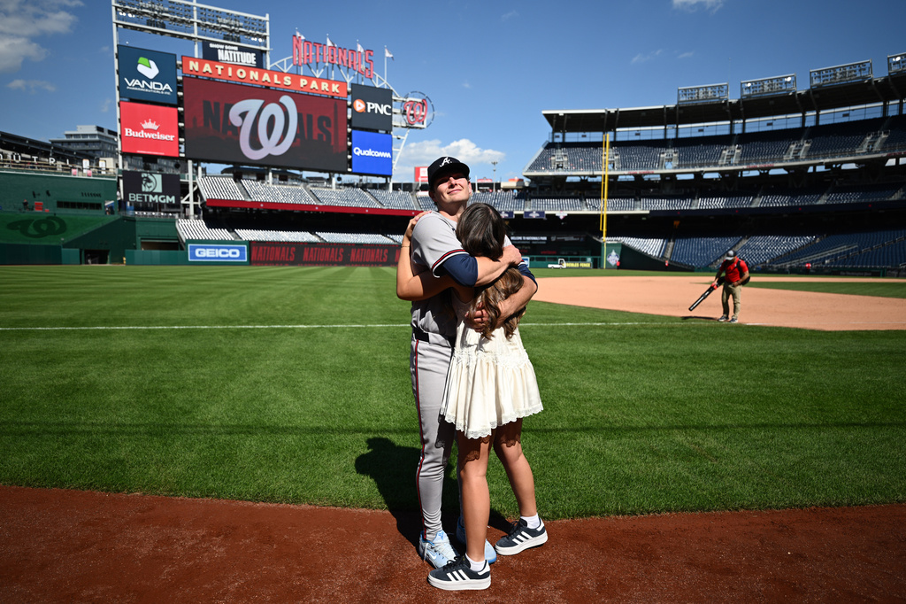 Atlanta Braves starting pitcher JR Ritchie, back, hugs his fiancée Makena Miller after winning his major league debut baseball game against the Washington Nationals, Thursday, April 23, 2026, in Washington. (AP Photo/Nick Wass)