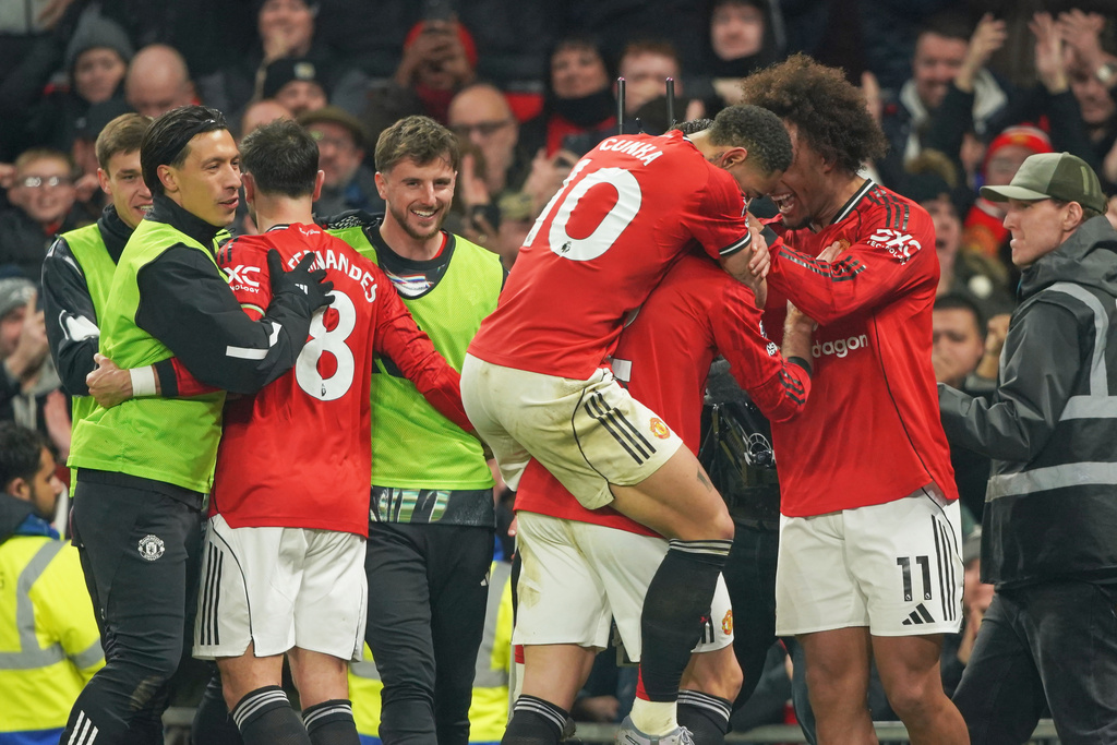 Manchester United players celebrate after Manchester United's Diogo Dalot scored his side's opening goal during the English Premier League soccer match between Manchester United and West Ham United in Manchester, England, Thursday, Dec. 4, 2025. (AP Photo/Ian Hodgson)