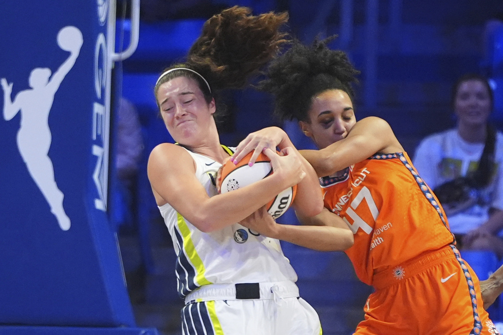 Connecticut Sun guard Leila Lacan (47) and Dallas Wings center Luisa Geiselsoder grab the ball during the first half of a WNBA basketball game in Arlington, Texas, Wednesday, Aug. 27, 2025. (AP Photo/LM Otero)