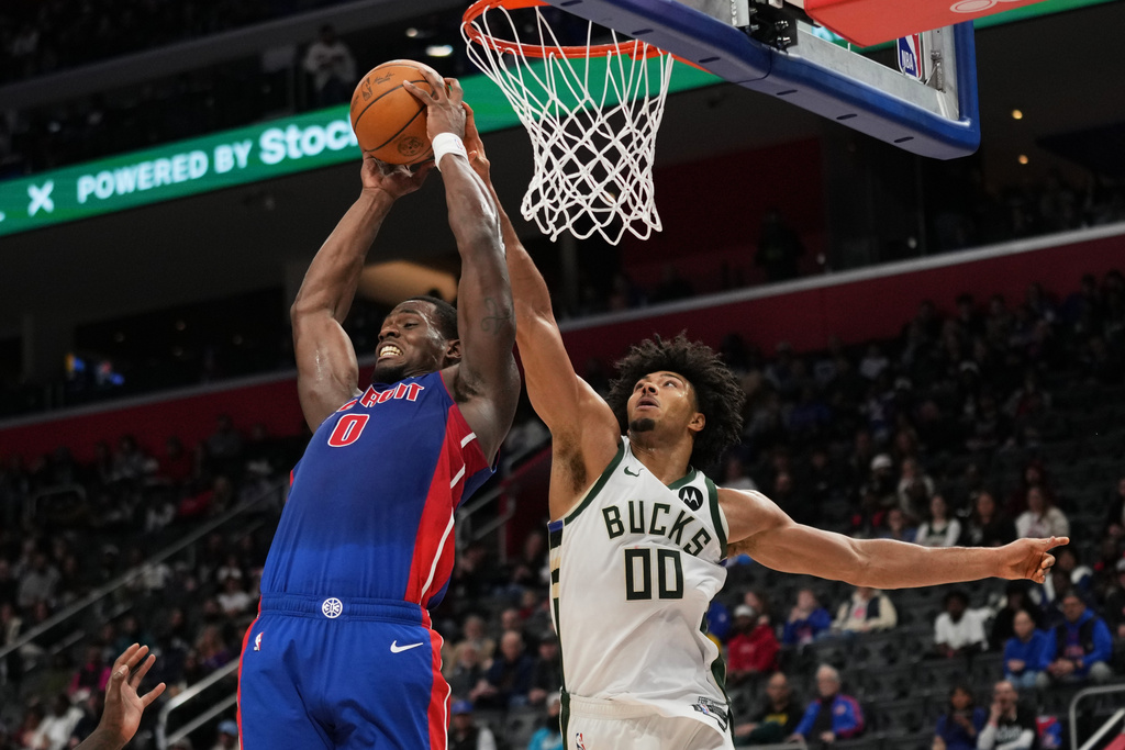 Detroit Pistons center Jalen Duren, left, and Milwaukee Bucks center Jericho Sims vie for a rebound during the first half of an NBA basketball game, Saturday, Dec. 6, 2025, in Detroit. (AP Photo/Ryan Sun)