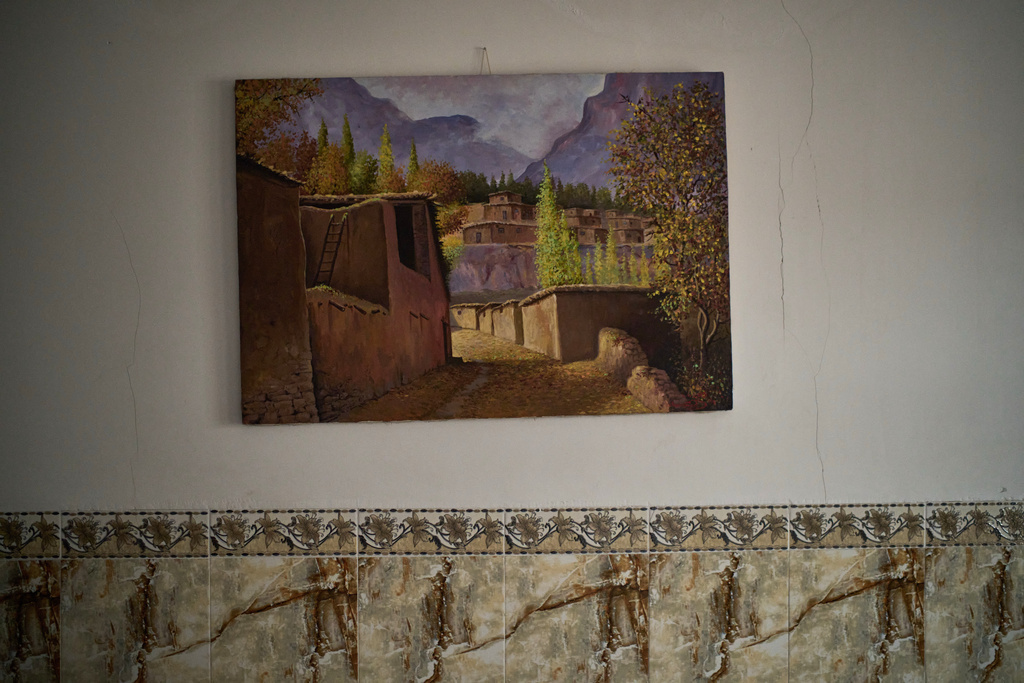 A painting showing houses and an alley of the village in Iran's Kurdish-majority Kermanshah province hangs on the wall of community leader Jehangir Ahmadi in Kawa Camp, made up of Iranian Kurdish refugees who fled Iran following the 1979 Islamic Revolution, in the outskirts of Irbil, Iraq, Saturday, March 14, 2026. (AP Photo/Leo Correa)