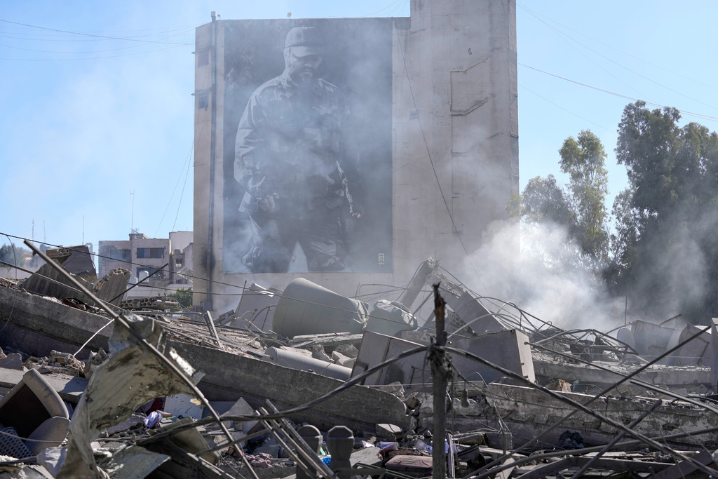 A giant poster shows the late Hezbollah military commander Imad Mughniyeh, behind a destroyed building that was hit by an Israeli airstrike in Nabatiyeh town, south Lebanon, Thursday, March 5, 2026. (AP Photo/Mohammed Zaatari)