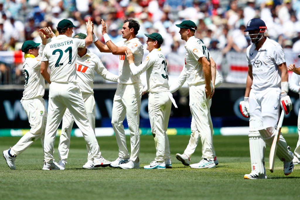 Australia's Mitchell Starc, center, celebrates with teammates the wicket of England's Gus Atkinson during the first Ashes cricket test match between Australia and England in Perth, Friday, Nov. 21, 2025.(AP Photo/Gary Day)
