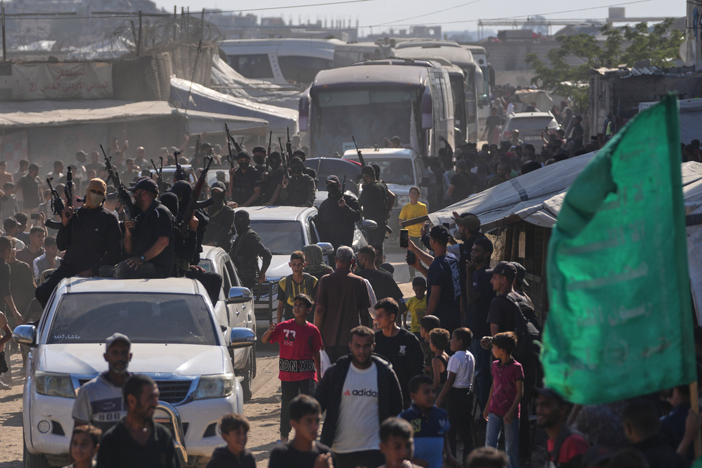 Hamas gunmen escort buses carrying freed Palestinian prisoners arriving in the Gaza Strip after their release from Israeli jails under a ceasefire agreement between Hamas and Israel, in Khan Younis, southern Gaza Strip, Monday, Oct. 13, 2025. (AP Photo/Jehad Alshrafi)