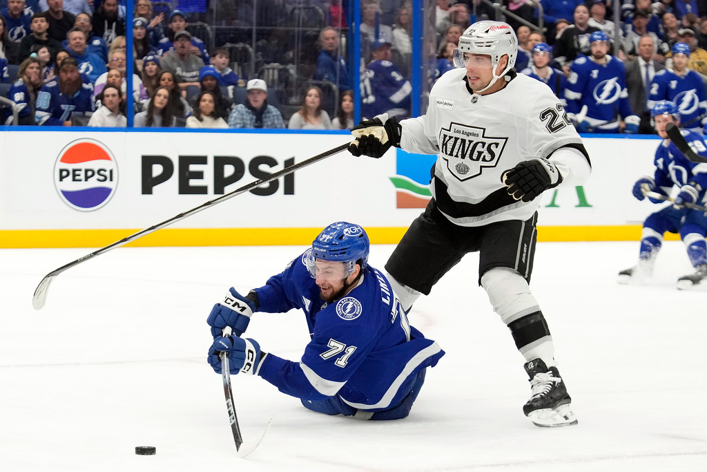 Tampa Bay Lightning center Anthony Cirelli (71) plays the puck after getting knocked down by Los Angeles Kings left wing Kevin Fiala (22) during the second period of an NHL hockey game Thursday, Dec. 18, 2025, in Tampa, Fla. (AP Photo/Chris O'Meara)