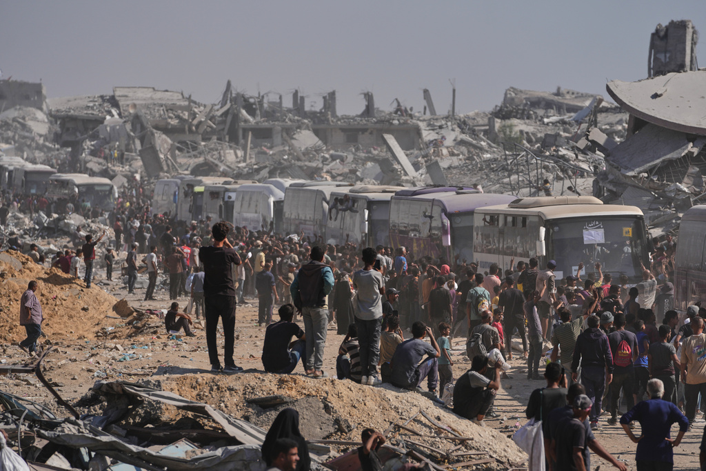 Buses carrying freed Palestinian prisoners drive past destroyed buildings in the Gaza Strip after their release from Israeli jails under a ceasefire agreement between Hamas and Israel, in Khan Younis, southern Gaza Strip, Monday, Oct. 13, 2025. (AP Photo/Jehad Alshrafi)