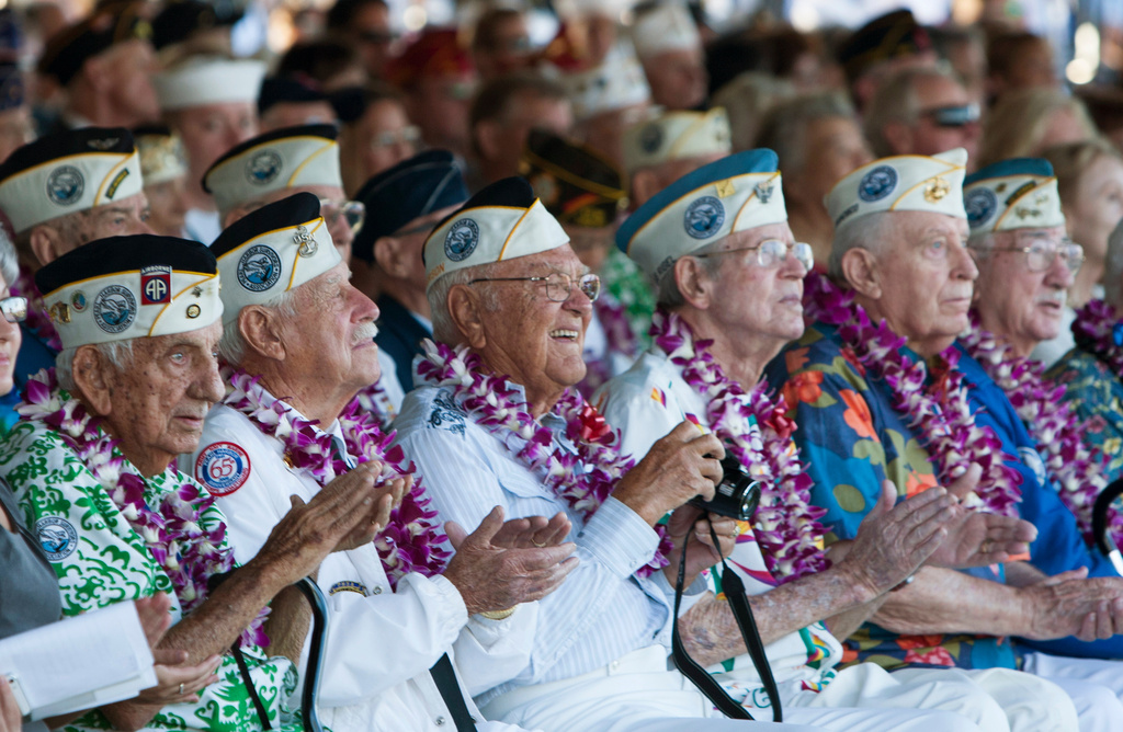FILE - Pearl Harbor survivors watch a vintage WWII airplane fly over Pearl Harbor at the ceremony commemorating the 72nd anniversary of the attack on Pearl Harbor, Dec. 7, 2013, in Honolulu. (AP Photo/Marco Garcia, File)