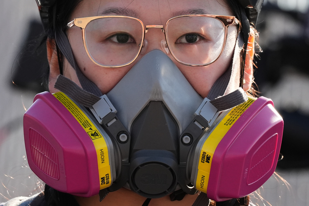 A protester wears a gas mask outside an ICE processing facility in the Chicago suburb of Broadview, Ill., Friday, Nov. 14, 2025. (AP Photo/Nam Y. Huh)