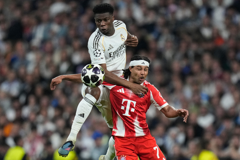 Real Madrid's Aurelien Tchouameni, top, and Bayern's Serge Gnabry challenge for the ball during the Champions League quarterfinal first leg soccer match between Real Madrid and Bayern Munich in Madrid, Spain, Tuesday, April 7, 2026. (AP Photo/Bernat Armangue)