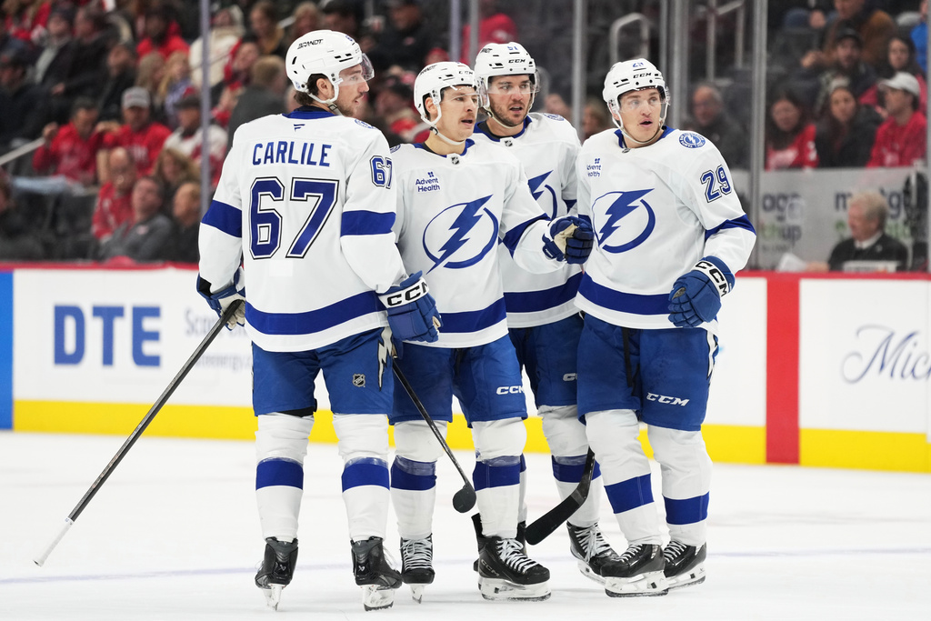 Tampa Bay Lightning center Yanni Gourde, second from left, celebrates with defenseman Declan Carlile, defenseman Charle-Edouard D'Astous, and right wing Pontus Holmberg after scoring during the second period of an NHL hockey game against the Detroit Red Wings Friday, Nov. 28, 2025, in Detroit. (AP Photo/Ryan Sun)