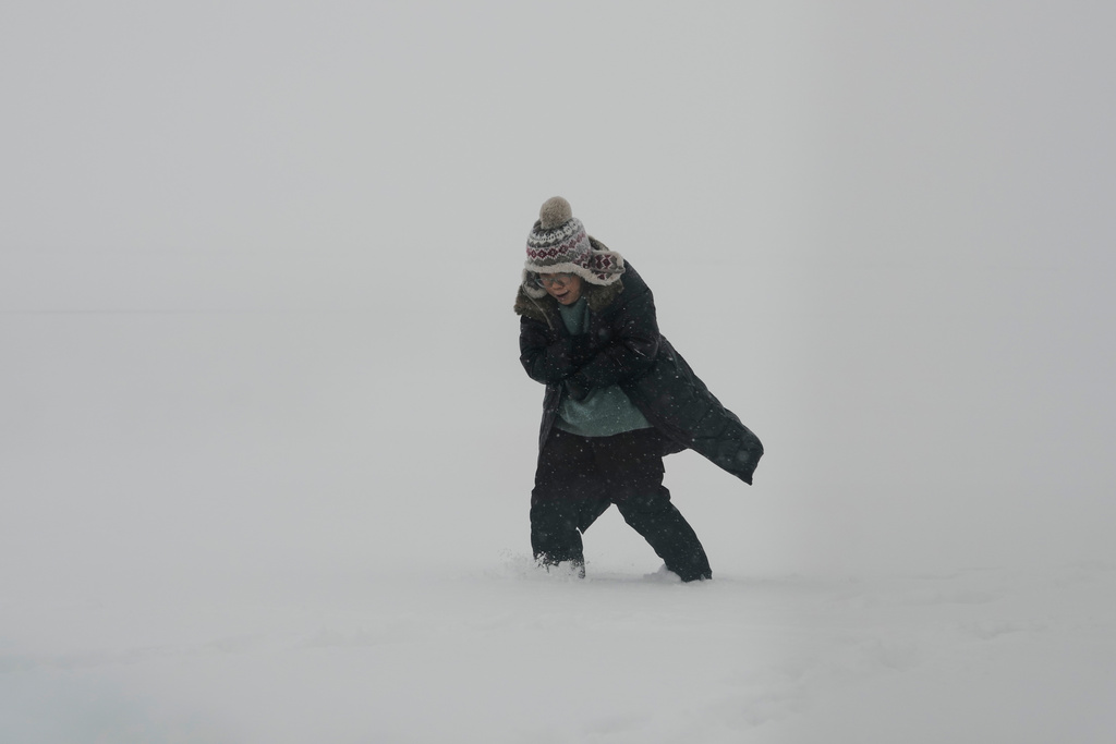 A person bundles up while walking along the shore of Lake Michigan at Montrose beach in Chicago, Sunday, Jan. 25, 2026. (AP Photo/Nam Y. Huh)