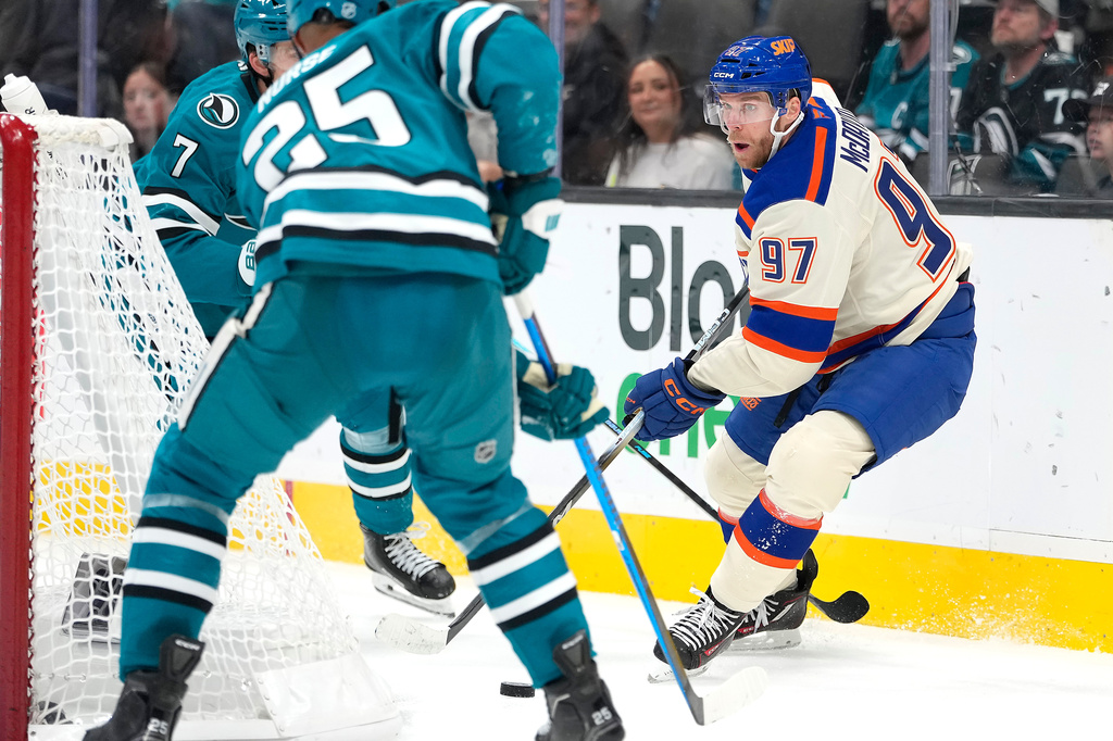 Edmonton Oilers center Connor McDavid (97) looks to pass the puck against San Jose Sharks defenseman Darnell Nurse (25) during the second period of an NHL hockey game in San Jose, Calif., Saturday, Oct. 10, 2026. (AP Photo/Tony Avelar)