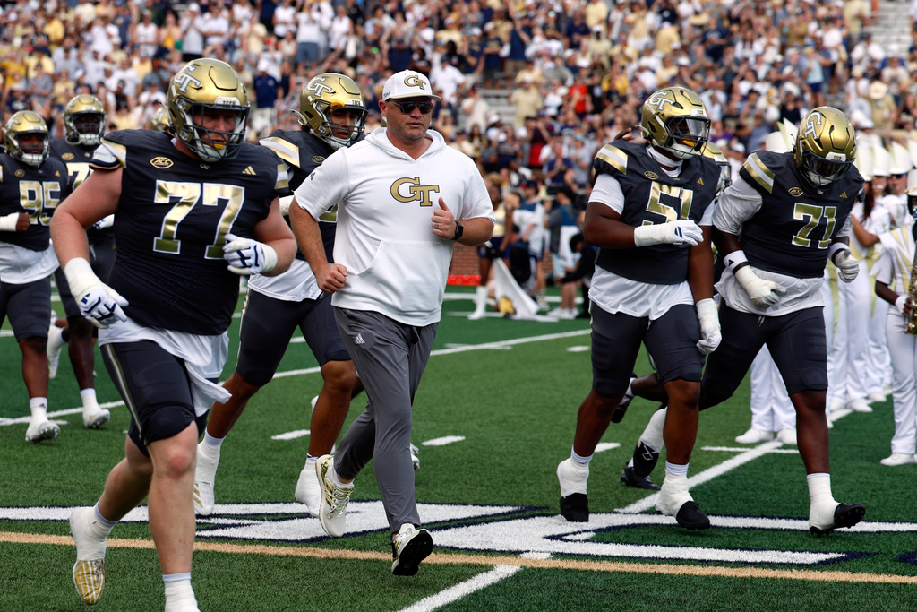 Georgia Tech head coach Brent Key, center left, leads his team onto the field before an NCAA college football game against Temple, Saturday, Sept. 20, 2025, in Atlanta. (AP Photo/Butch Dill)