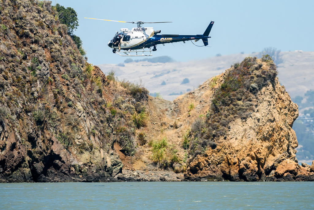 A California Highway Patrol helicopter flies along the Sausalito, Calif., shoreline as search and rescue operations continue after a Tuesday boat sinking on Wednesday, July 15, 2026. (AP Photo/Noah Berger)