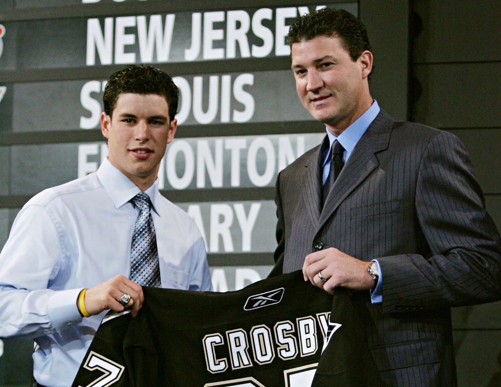 FILE - The No. 1 overall pick in the NHL draft Sidney Crosby, left, of Dartmouth, N.S., holds up his new Pittsburgh Penguins jersey with team owner Mario Lemieux at the NHL entry draft in Ottawa, Ontario, July 30, 2005. (Jonathan Hayward/The Canadian Press via AP, File)