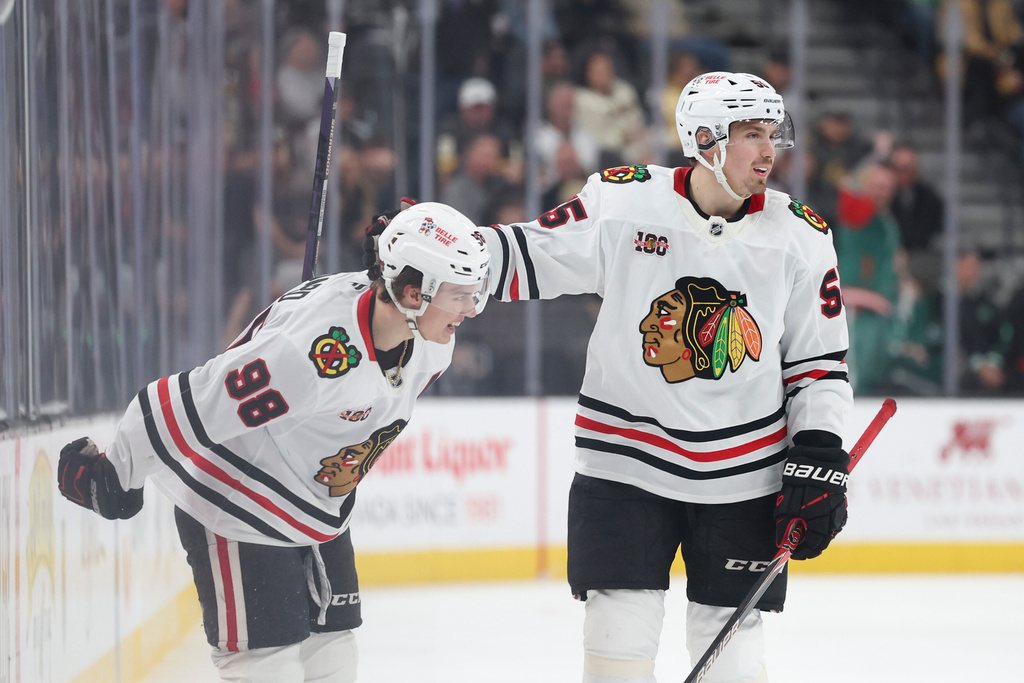 Chicago Blackhawks center Connor Bedard (98) and defenseman Artyom Levshunov (55) celebrate after Bedard's goal against the Vegas Golden Knights during the third period of an NHL hockey game Tuesday, Dec. 2, 2025, in Las Vegas. (AP Photo/Ian Maule)