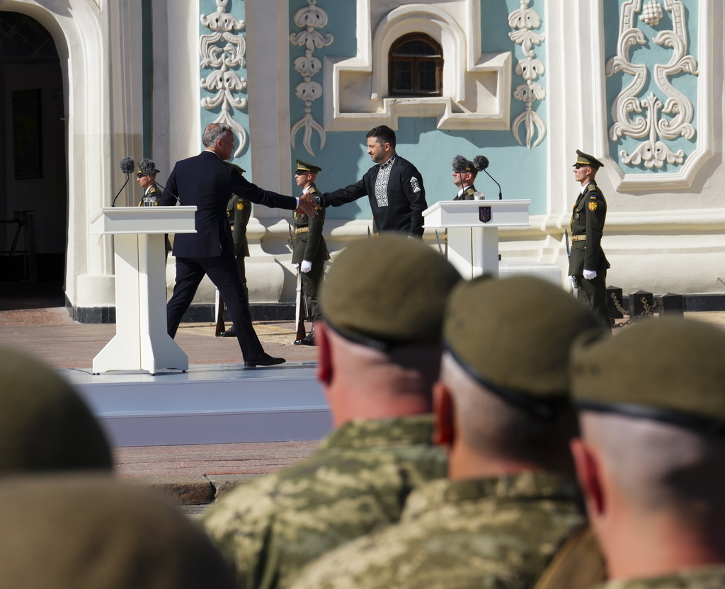 Canada's Prime Minister Mark Carney shakes hands with Ukrainian President Volodymyr Zelenskyy following their speeches, during a ceremony on Independence Day in Sophia Square, in Kyiv, Ukraine, on Sunday, Aug. 24, 2025. (Sean Kilpatrick//The Canadian Press via AP)