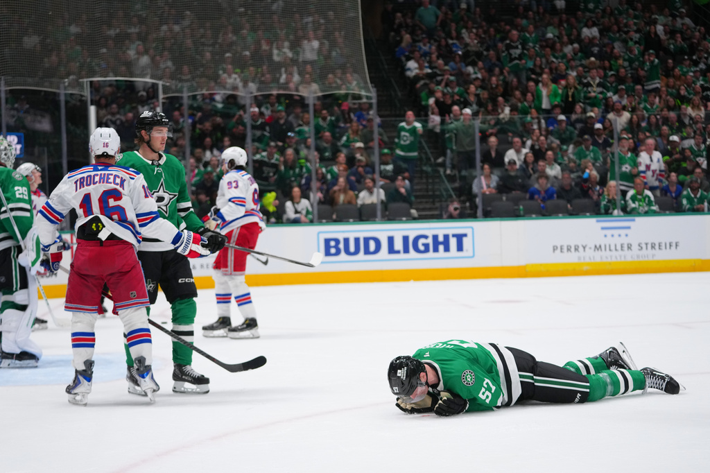Dallas Stars defenseman Tyler Myers (57) lies on the ice after taking a hit from New York Rangers center Vincent Trocheck (16) during the second period of an NHL hockey game Saturday, April 11, 2026, in Dallas. (AP Photo/Julio Cortez)