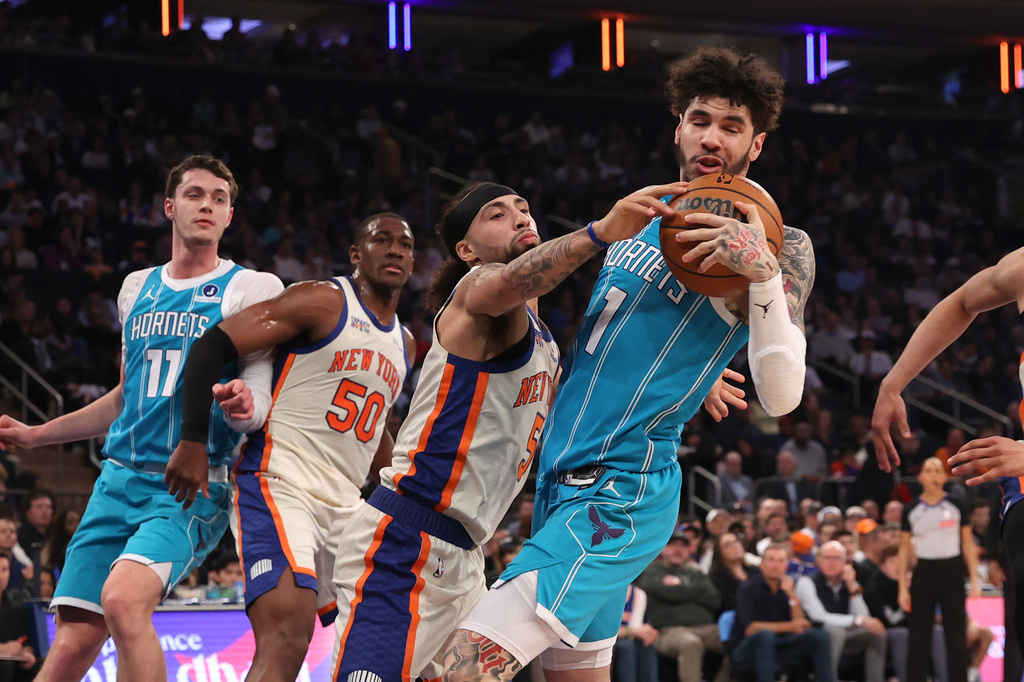 New York Knicks' Jose Alvarado (5) attempts to steal the ball from Charlotte Hornets' LaMelo Ball (1) during the first half of an NBA basketball game Sunday, April 12, 2026, in New York. (AP Photo/Pamela Smith)