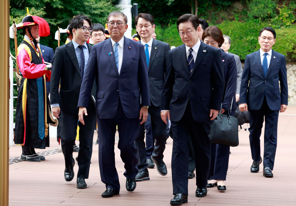 South Korean President Lee Jae Myung, center right, and Japanese Prime Minister Shigeru Ishiba, center left, arrive to hold a meeting in Busan, South Korea, Tuesday, Sept. 30, 2025. (Yonhap via AP)