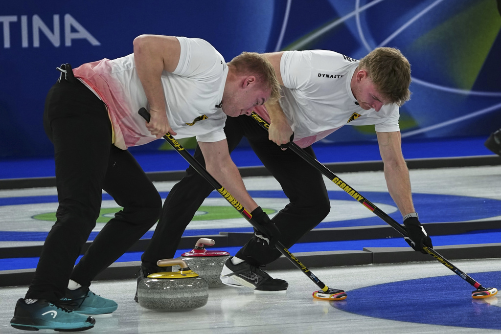 Germany's Johannes Scheuerl, right, and Felix Messenzehl in action during the men's curling round robin session against Canada, at the 2026 Winter Olympics, in Cortina d'Ampezzo, Italy, Wednesday, Feb. 11, 2026. (AP Photo/Misper Apawu)