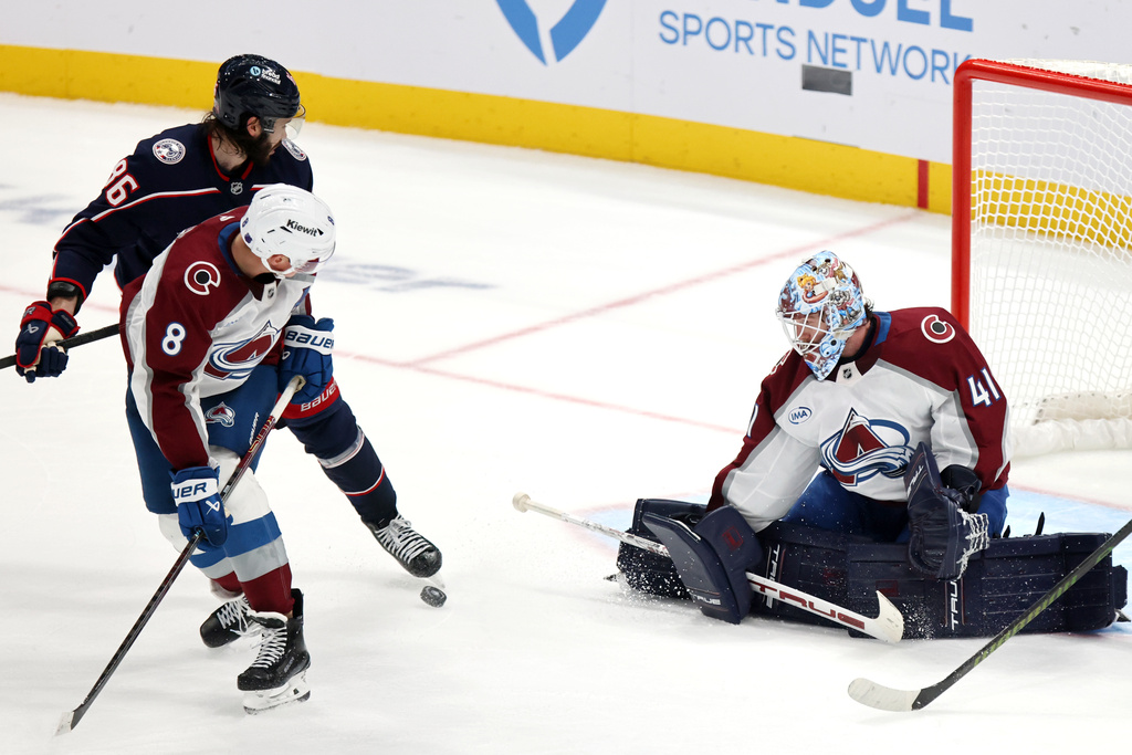 Colorado Avalanche goalie Scott Wedgewood, right, makes a stop in front of teammate defenseman Cale Makar, center, and Columbus Blue Jackets forward Kirill Marchenko during the third period of an NHL hockey game in Columbus, Ohio, Thursday, Oct. 16, 2025. (AP Photo/Paul Vernon)