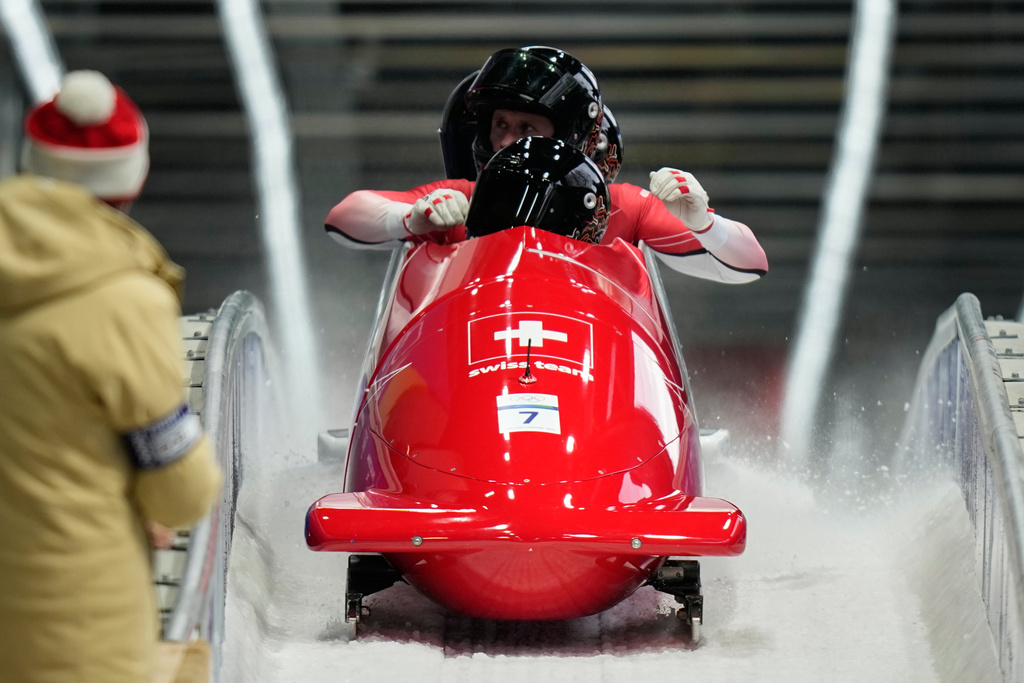 Switzerland's Michael Vogt, front Andreas Haas, Amadou David Ndiaye and Mario Aeberhard arrive at the finish during a four man bobsled run at the 2026 Winter Olympics, in Cortina d'Ampezzo, Italy, Sunday, Feb. 22, 2026. (AP Photo/Aijaz Rahi)