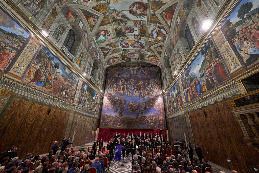 Conductor Harry Christopher, center, with tenor Matthew McKinney, left, soprano Elizabeth Watts, second from left, and The Sixteen present Angels Unawares byJames MacMillan in the Sistine Chapel at the Vatican, Sunday, March 22, 2026. (AP Photo/Domenico Stinellis)