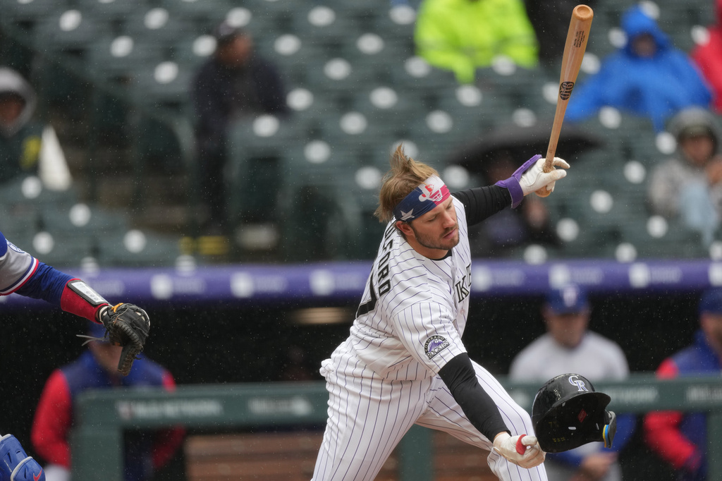 Colorado Rockies pinch-hitter Braxton Fulford catches his batting helmet as he strikes out against Texas Rangers relief pitcher Jacob Latz in the ninth inning of a baseball game Wednesday, May 20, 2026, in Denver. (AP Photo/David Zalubowski)