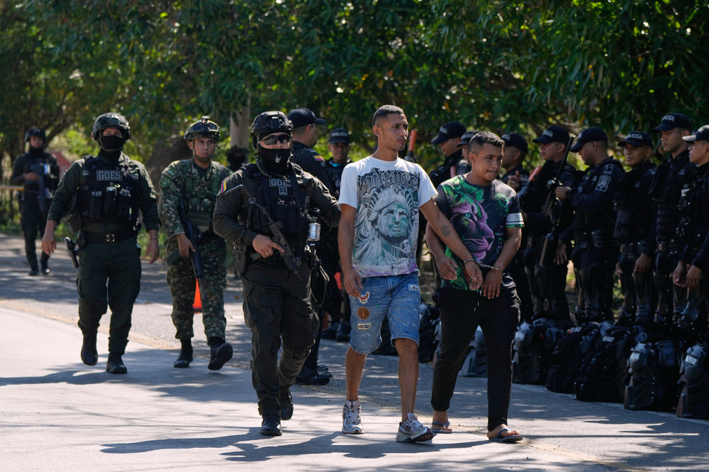 Police escort two alleged paramilitary members, handcuffed to each other, after their detention in Santa Marta, Colombia, Wednesday, Sept. 23, 2026. (AP Photo/Fernando Vergara)