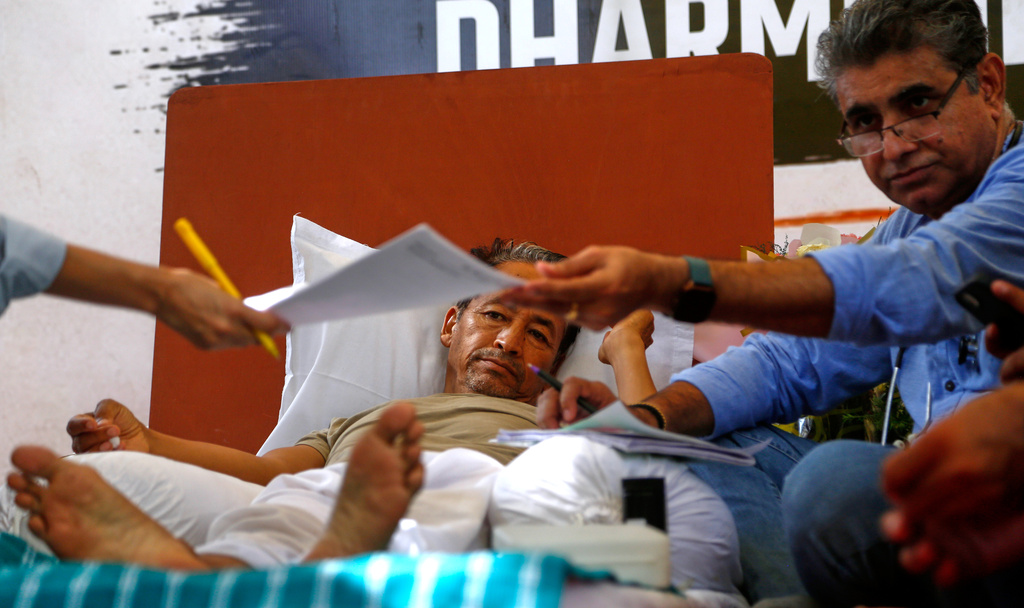 A doctor, right, examines educationist and climate activist Sonam Wangchuk, center, who undertakes an indefinite hunger strike during a Cockroach Janta Party protest demanding the resignation of India's Education Minister Dharmendra Pradhan over alleged examination irregularities and repeated paper leaks in New Delhi, India, Thursday, July 16, 2026. (AP Photo/Shekhar Yadav)