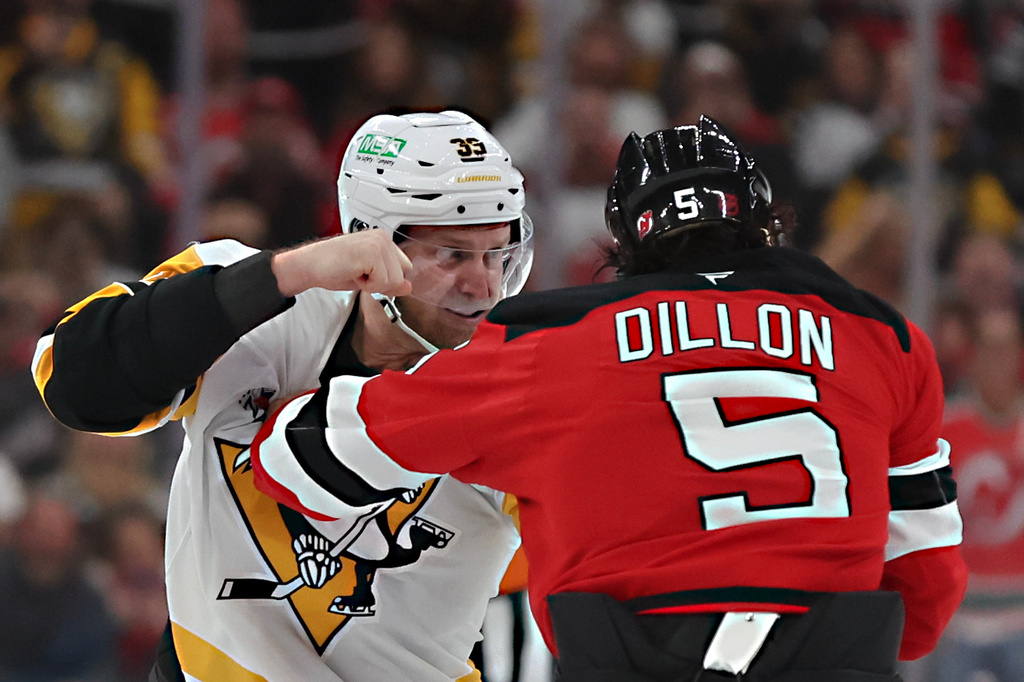 Pittsburgh Penguins right wing Anthony Mantha (39) and New Jersey Devils defenseman Brenden Dillon (5) fight during the first period of an NHL hockey game, Saturday, Nov. 8, 2025, in Newark, N.J. (AP Photo/Heather Khalifa)