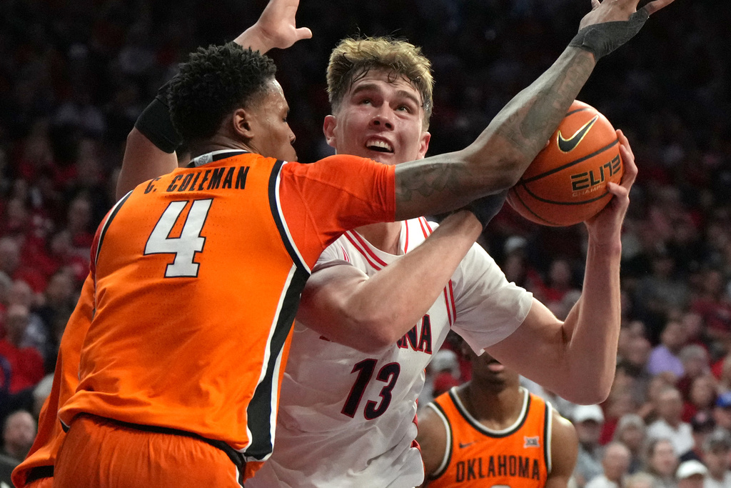 Arizona center Motiejus Krivas (13) drives on Oklahoma State forward Christian Coleman during the second half of an NCAA college basketball game, Saturday, Feb. 7, 2026, in Tucson, Ariz. (AP Photo/Rick Scuteri)