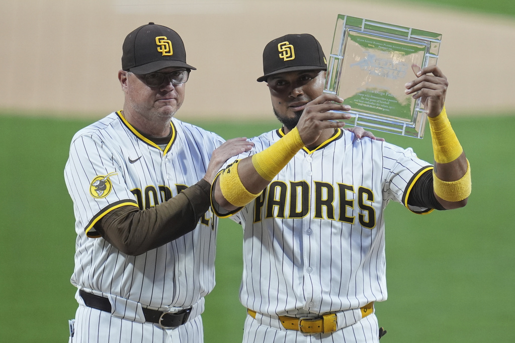 San Diego Padres first baseman Luis Arraez, right, holds the Heart & Hustle Award for the San Diego Padres as he stands alongside manager Mike Shildt after winning the award before a baseball game against the Milwaukee Brewers Monday, Sept. 22, 2025, in San Diego. (AP Photo/Gregory Bull)